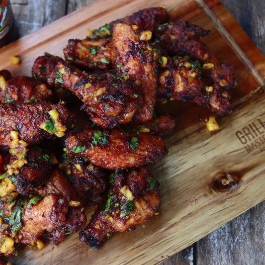 Crispy, saucy chicken wings using Be My Wingman BBQ Box products on a Grill Masters Club cutting board