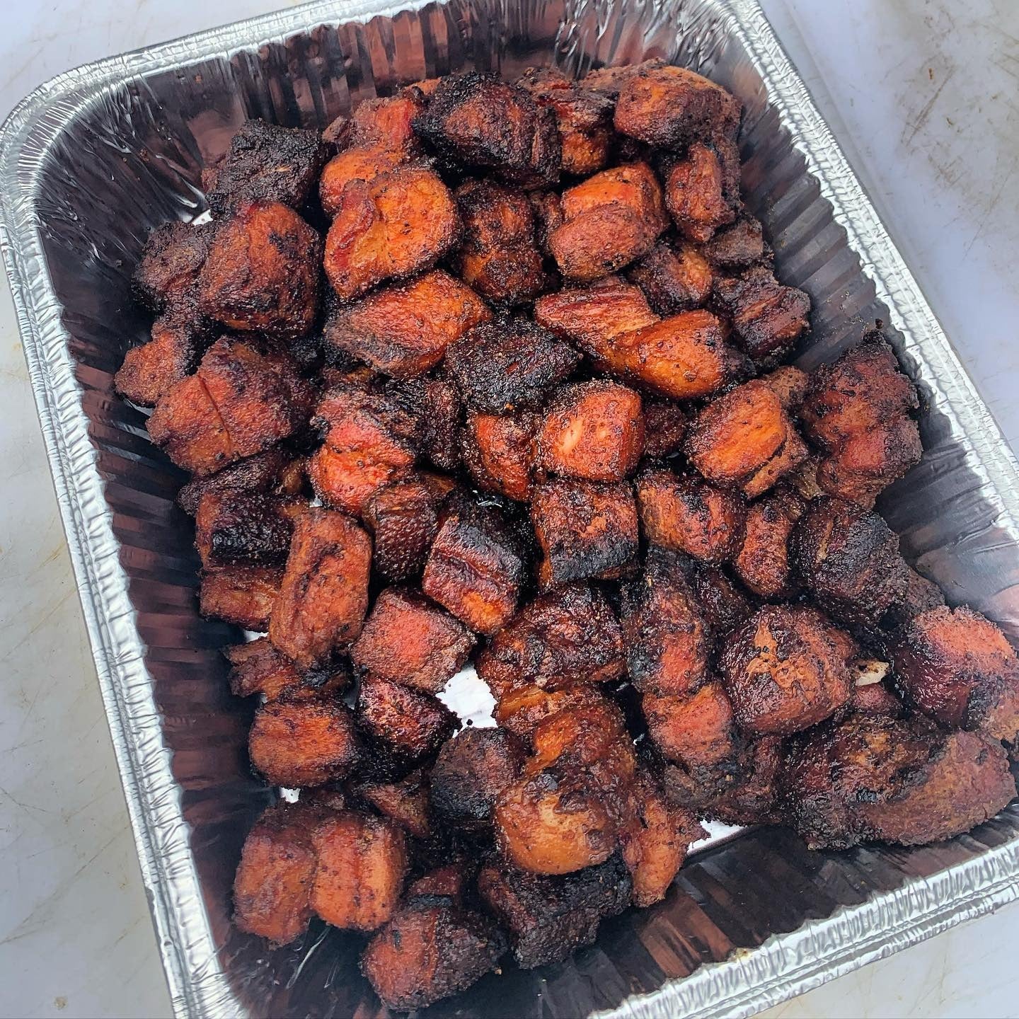 Close-up of caramelized pork belly burnt ends with glaze from blueberry chipotle bourbon sauce